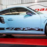 Blue sports car with 'GT3RS' decal on a red carpet indoors